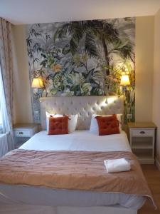 布鲁瓦Logis Hôtel Louise de Savoie的卧室配有带橙色枕头的大型白色床