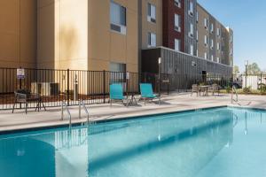 查塔努加TownePlace Suites by Marriott Chattanooga South, East Ridge的一座带桌椅的游泳池以及一座建筑