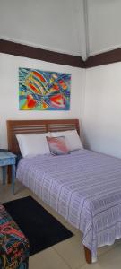 布希奥斯Hospedagem Tucanos的一间卧室配有一张带紫色棉被的床
