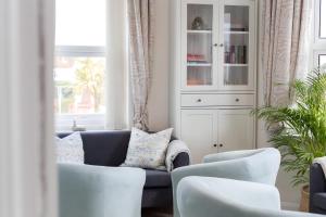 浦耳Poole Park House的客厅配有蓝色的沙发和白色的椅子