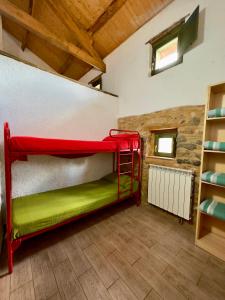 Cubillas de ArbasAlbergue Valle de Arbas的木制天花板的客房内的红色双层床