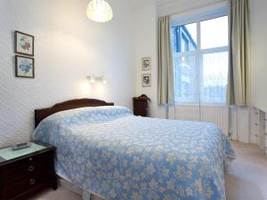 北希尔兹Seafront Apartments的一间卧室配有一张带蓝色棉被的床和窗户。