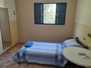 特雷斯拉瓜斯HOTEL NOVO HOTEL的一间卧室配有一张床、一张桌子和一个窗户。