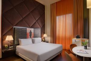 米兰诺奥米兰酒店的酒店客房配有一张床铺和一张桌子。