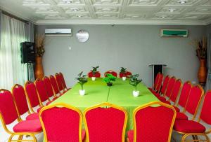 TokuseULTIMATE HOTEL的一间会议室,配有桌子和红色椅子
