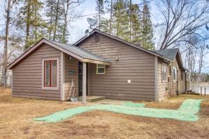 德卢斯Waterfront Duluth Cabin with Deck and River View!的一间棕色的小房子,配有卫星