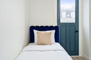 蒙特利尔Clouds Boutique Hotel的一间卧室设有一扇蓝色的门和一张带枕头的床