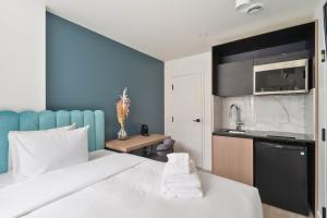 蒙特利尔Clouds Boutique Hotel的酒店客房带一张床和一个厨房