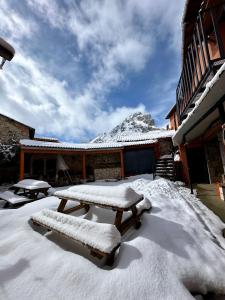 Cubillas de ArbasAlbergue Valle de Arbas的房屋前的雪地野餐桌