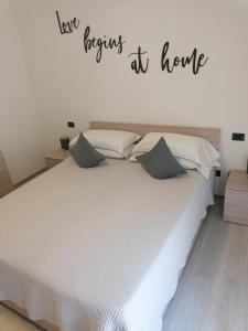 阿科Appartamento Meridiana的卧室配有一张白色的床,上面标有读物,在家中祈祷