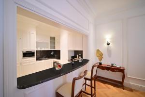 多哈21 High Street Residence的厨房配有白色橱柜和黑色台面