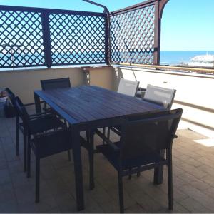 丽都迪奥斯蒂亚Casa Paradiso的阳台上的木桌和椅子
