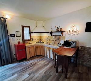 比森齐奥营MARCONI DEPENDANCE的厨房配有木桌和红色冰箱。