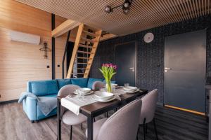 索利纳SOWI GAJ - domki całoroczne的一间配备有蓝色沙发及桌椅的用餐室