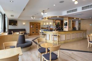 伦敦伦敦 - 温布利国际酒店的餐厅设有酒吧和桌椅