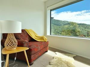 皮克顿Picton Hilltop Apartment的客厅设有红色的沙发和窗户。