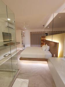 图卢姆Kuun Taak Tulum的卧室配有白色的床和玻璃墙