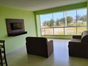 卡庞达卡诺阿Residencial Veleiros Do Mar的客厅设有两张沙发和一个大窗户