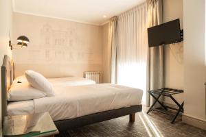 蓬塔阿雷纳斯何塞·诺盖拉酒店的酒店客房,配有床和电视