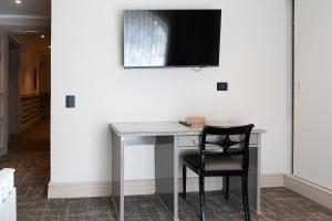 蓬塔阿雷纳斯何塞·诺盖拉酒店的一张桌子、椅子和墙上的电视