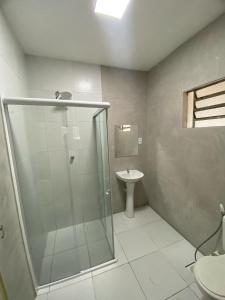 若昂佩索阿Pousada Manaíra的一间带玻璃淋浴和水槽的浴室
