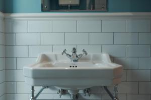 Whaley BridgeThe Jodrell Luxury Suites的白色瓷砖浴室内的白色水槽