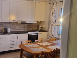 Holiday home BONÄSSUND的厨房配有桌椅和白色橱柜。