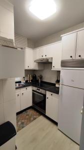 坎加斯德穆拉索CasacheloCangas的厨房配有白色橱柜和黑色用具