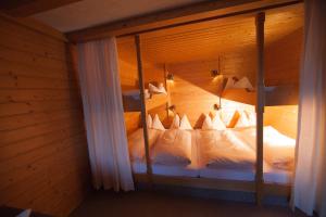 利恩茨约芬塔勒泽特菲尔德旅馆的木制客房内的一间卧室配有两张双层床