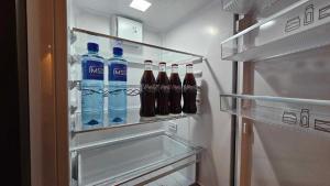 奥勒松West Coast Apartments Aalesund的装满苏打水瓶的开放式冰箱