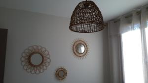 艾格伦Appartement à la campagne的一间房间,墙上有两面镜子和吊灯