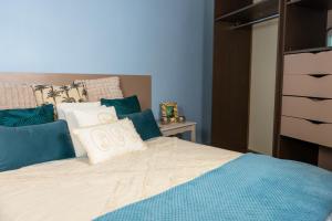拉瓦勒Chez Nous Laval的一张带蓝色和白色枕头的床