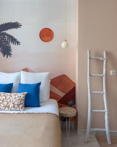 讷韦尔"Le Majorelle" logement atypique en hyper centre, avec service premium by PRIMO C0NCIERGERIE的一间卧室配有一张带蓝色枕头的床和梯子
