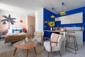 讷韦尔"Le Majorelle" logement atypique en hyper centre, avec service premium by PRIMO C0NCIERGERIE的客厅以及带床和桌子的厨房。