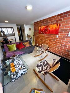 圣罗莎德卡瓦尔Maravilloso alojamiento para tu familia的带沙发和砖墙的客厅