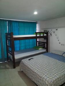 卡塔赫纳Del Castillo Mirador Hostel的一间卧室配有两张双层床和蓝色窗帘