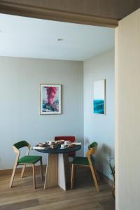 马德里The Oliver Apartamentos Aravaca的一间带桌子和两把椅子的用餐室