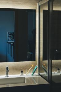 马德里The Oliver Apartamentos Aravaca的浴室水槽配有镜子和牙刷