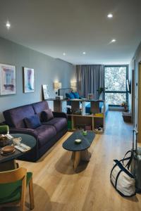 马德里The Oliver Apartamentos Aravaca的客厅配有紫色沙发和桌子