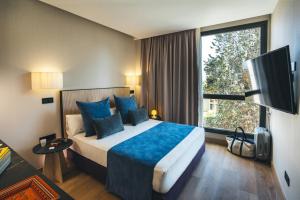 马德里The Oliver Apartamentos Aravaca的酒店客房设有一张床和一个大窗户