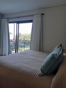 本塔纳山村Los Robles Apart Hotel的一间卧室设有一张床和一个大窗户