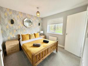 福克斯通3 Bedroom Home centrally located in Folkestone, great location for contractors or families with parking的一间卧室配有一张带黄色床单的大床和窗户。