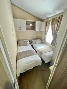 温德米尔Windermere View Lodge - White Cross Bay的小房间设有两张床和窗户
