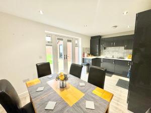 福克斯通3 Bedroom Home centrally located in Folkestone, great location for contractors or families with parking的厨房以及带桌椅的用餐室。