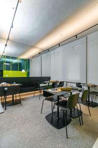 阿西西Elide Design Hotel的配有桌椅和投影屏幕的教室