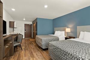 柯林斯堡WoodSpring Suites Fort Collins的酒店客房配有两张床和一张书桌
