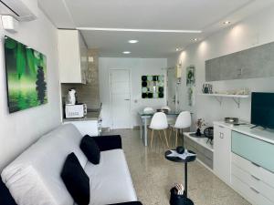 卡尔佩Estudios HORIZONTE BEACH的一间带白色沙发的客厅和一间厨房