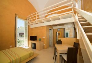 加利波利Relais Carlo V - Palazzo Storico的一间带高架床的卧室和一间带桌子的用餐室