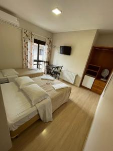 卡内拉Pousada Folhas de Outono的酒店客房设有两张床和电视。