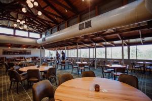 黄金海岸Wallaby Hotel的餐厅设有木桌和椅子以及大窗户。